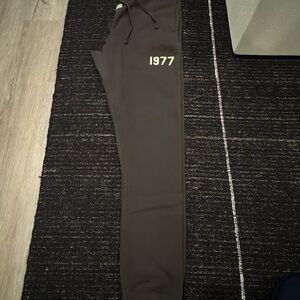FEAR OF GOD ESSENTIALS Black Joggers with 1977 Print